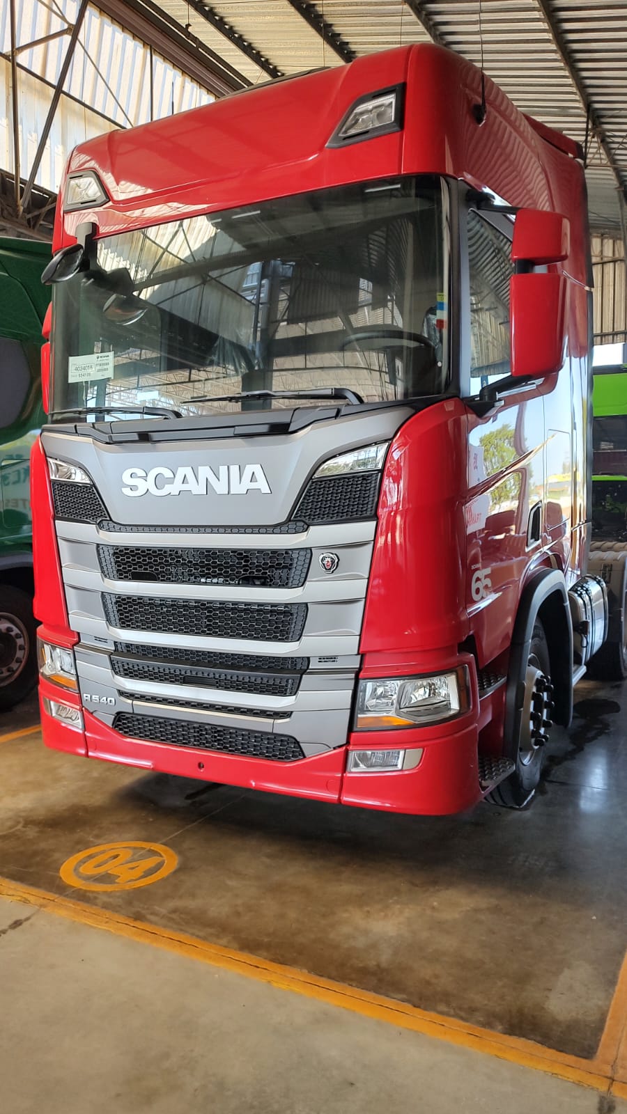 Caminhão Scania R540 vermelho em pátio coberto