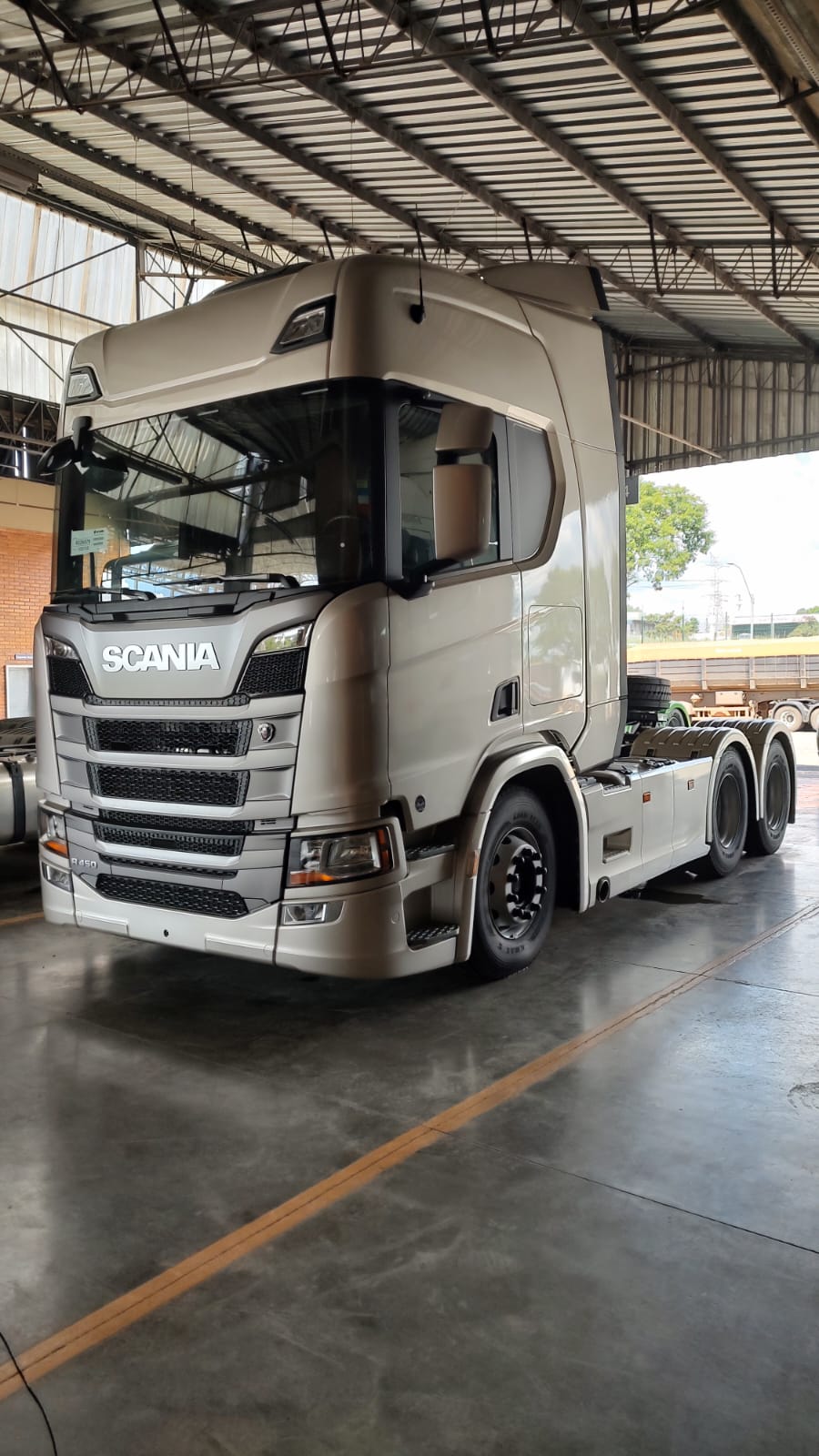 Caminhão Scania R450 prata em pátio coberto