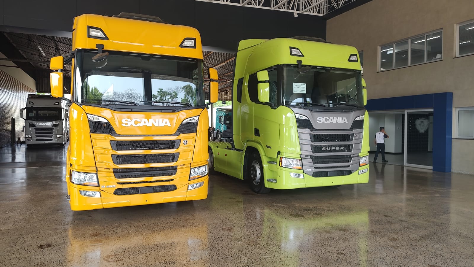 Caminhões Scania amarelo e verde em concessionária